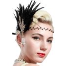 Women's 1920s flapper headpiece with black feather plume and rose gold Art Deco rhinestone brooch worn with jeweled chain headband