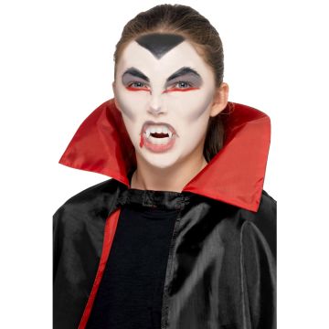 Kids vampire makeup kit with tri-color face paints, plastic fangs, stipple sponge and applicator brush in white compact