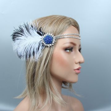 Close-up of blue rhinestone sunburst brooch with black-tipped ostrich feathers