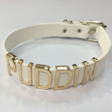 White faux leather choker with gold PUDDIN letters and buckle closure