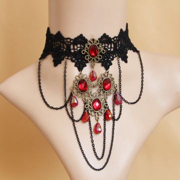 Ornate bronze pendant detail showing oval red gemstones and cascading teardrop dangles with AB coating