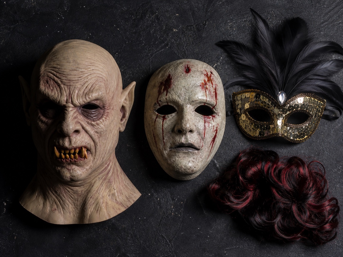 A flat-lay comparison of full-head, face-only and eye Halloween masks with a costume wig
